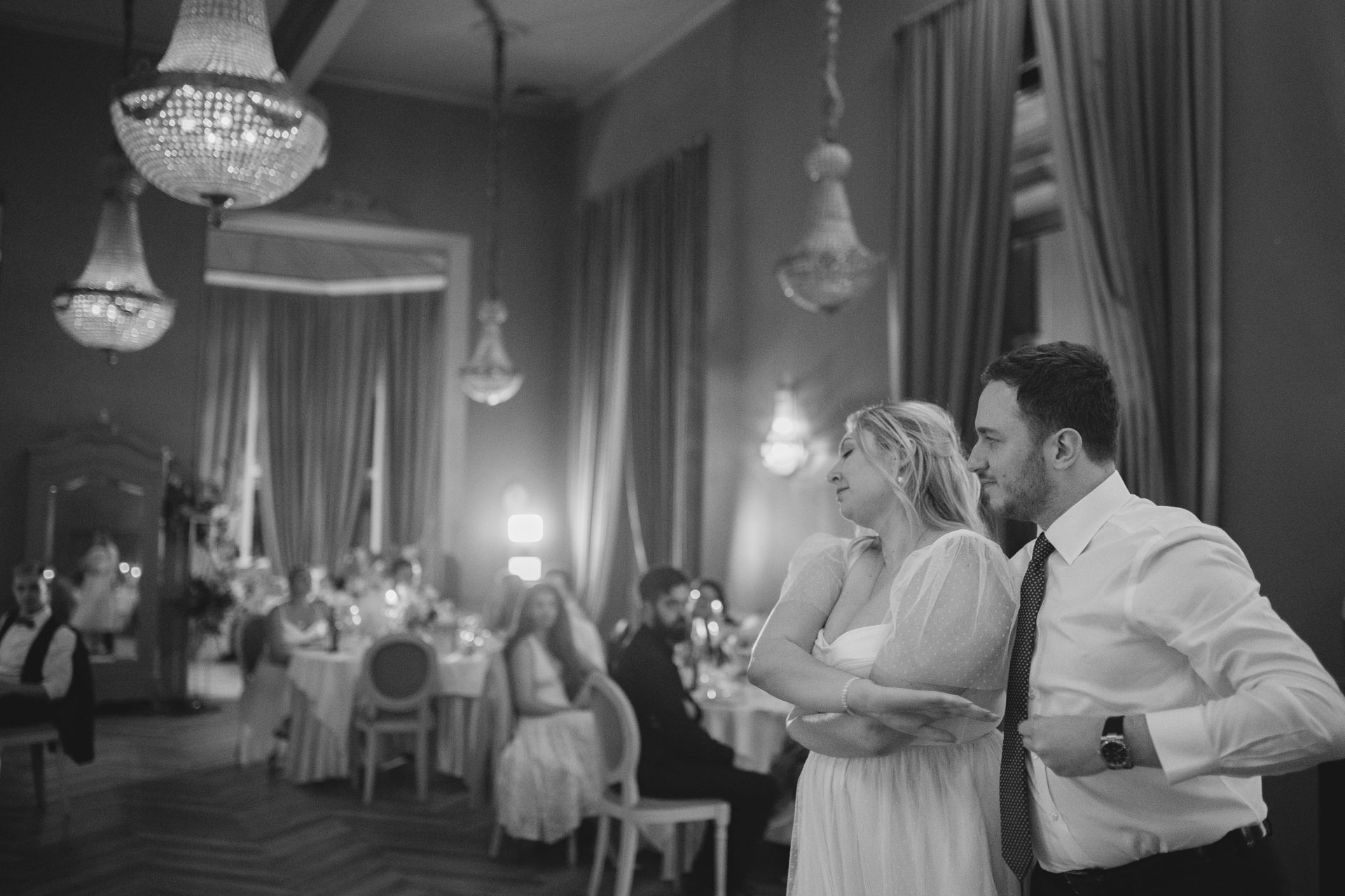 Les mariés regardent la salle en souriant pendant un discours ou un moment émouvant
