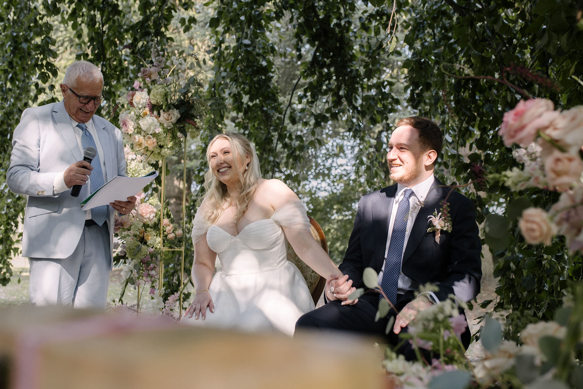 Le couple échangeant un regard complice avec l’officiant qui lit un texte avec humour