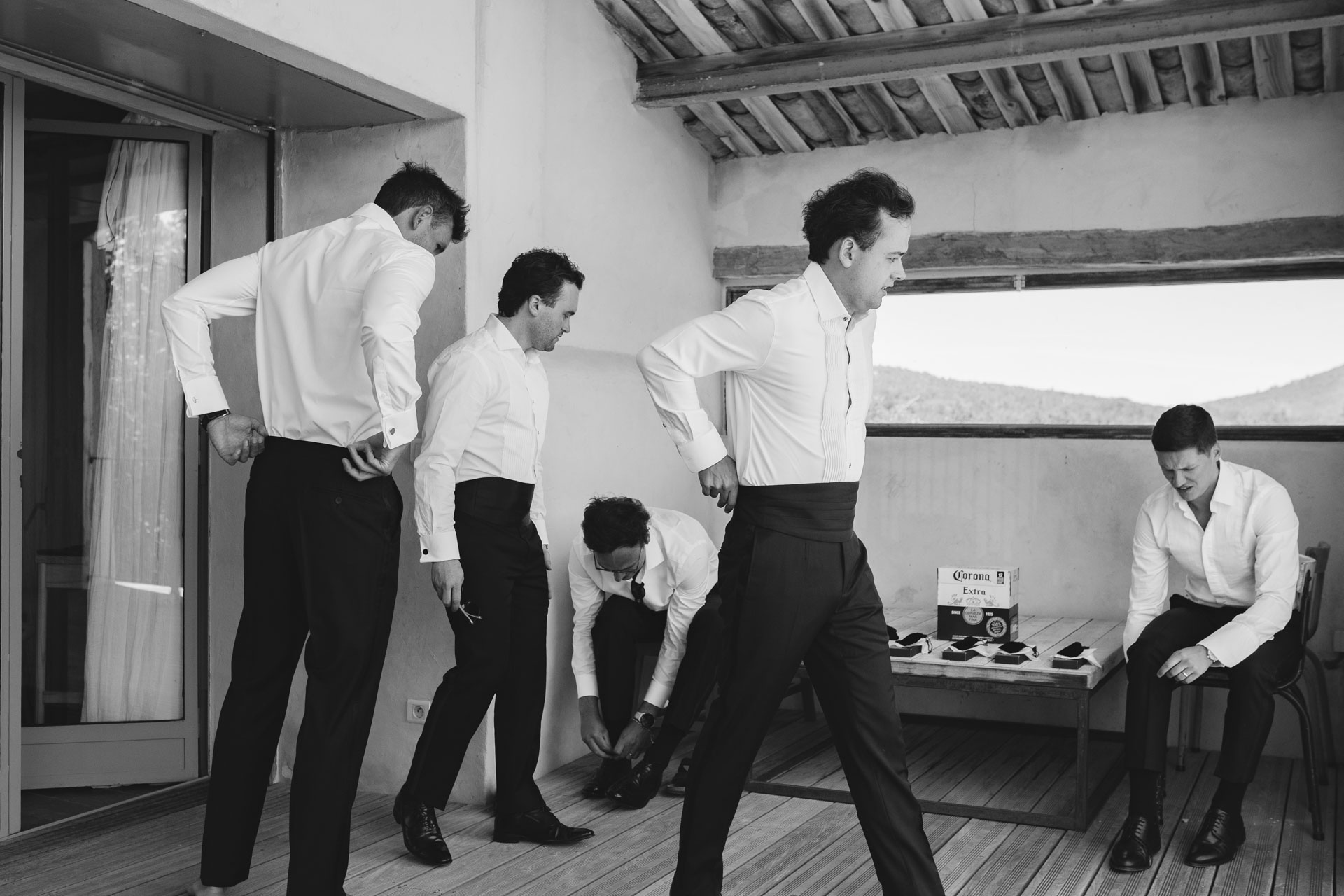Groomsmen putting on their shoes, black and white — Grange de Javon, Provence