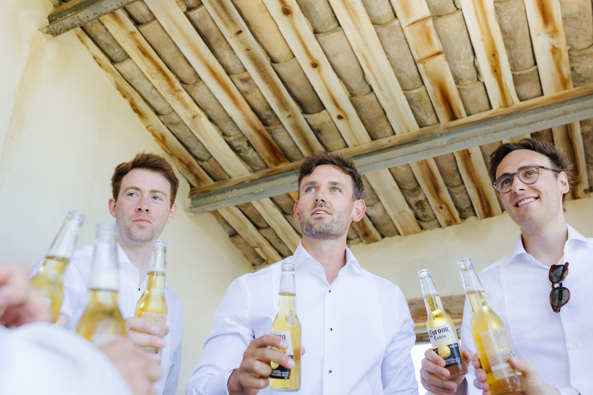 Groomsmen toasting with a beer while getting ready — Grange de Javon, Provence
