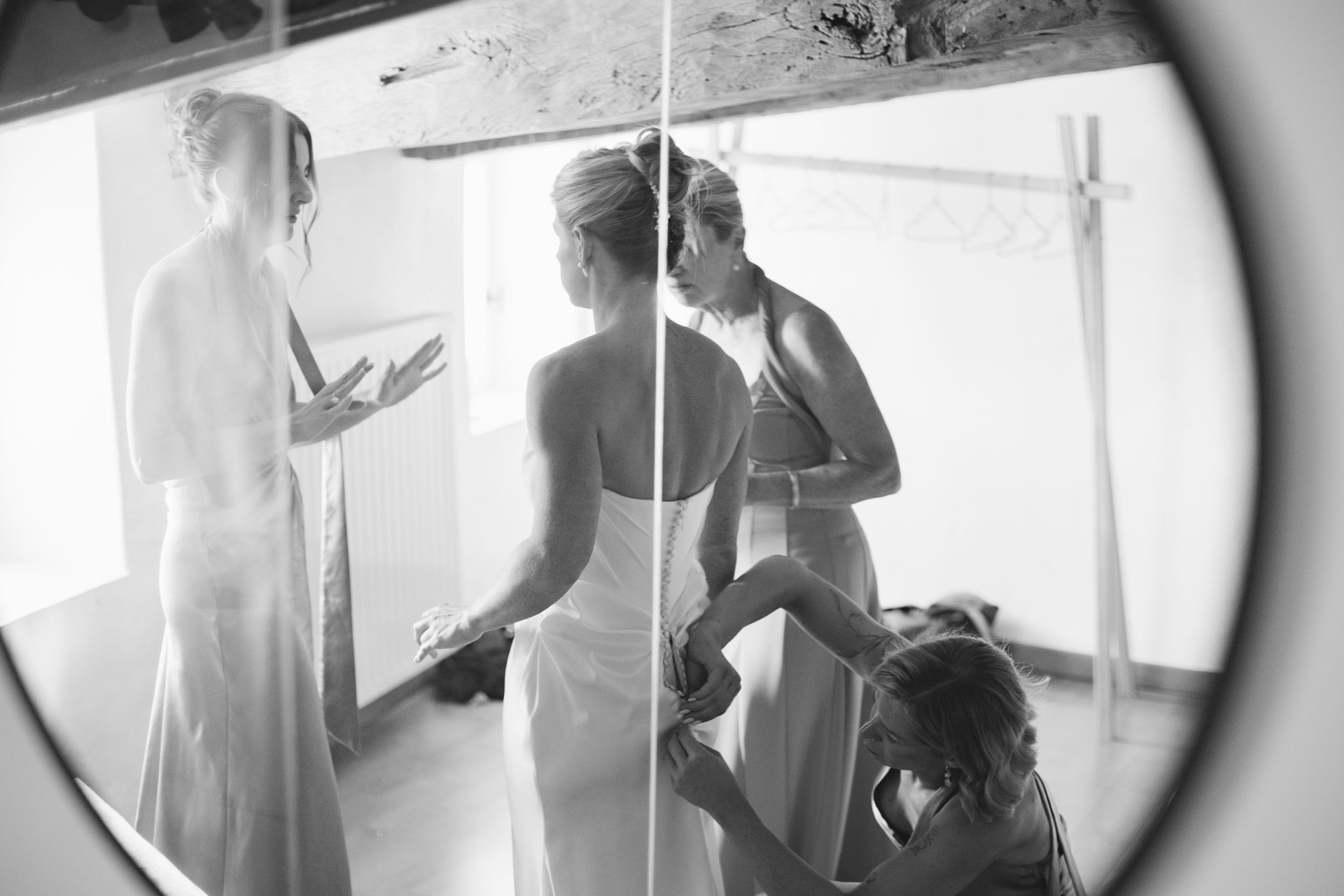 Bride stepping into her gown by a bright window — Grange de Javon wedding preparations