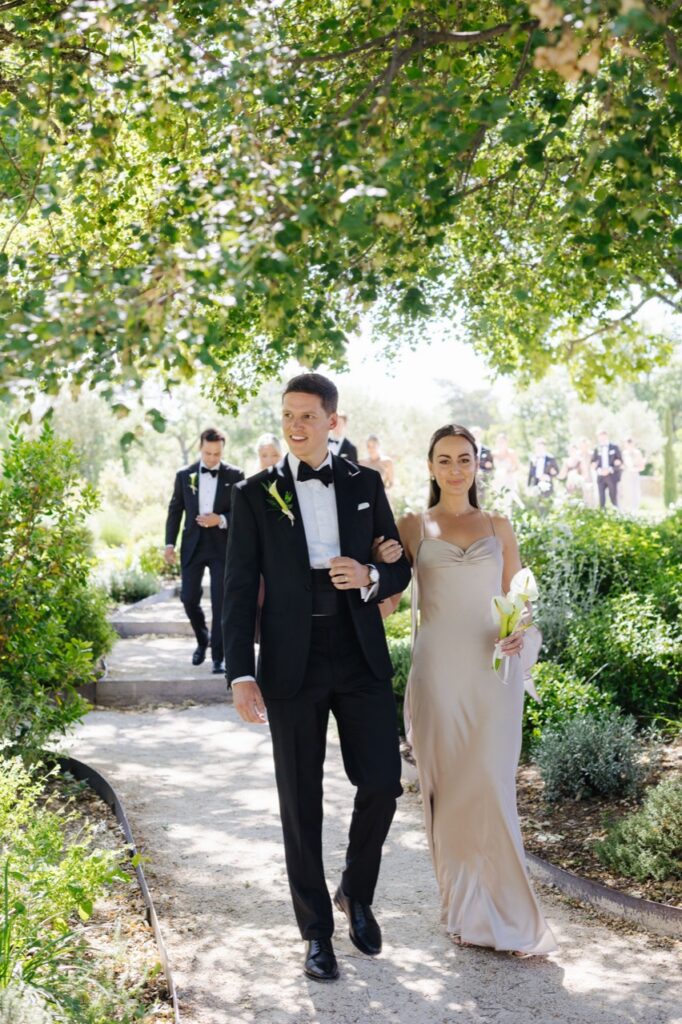 Wedding party arriving for the ceremony under the trees — Grange de Javon, Provence