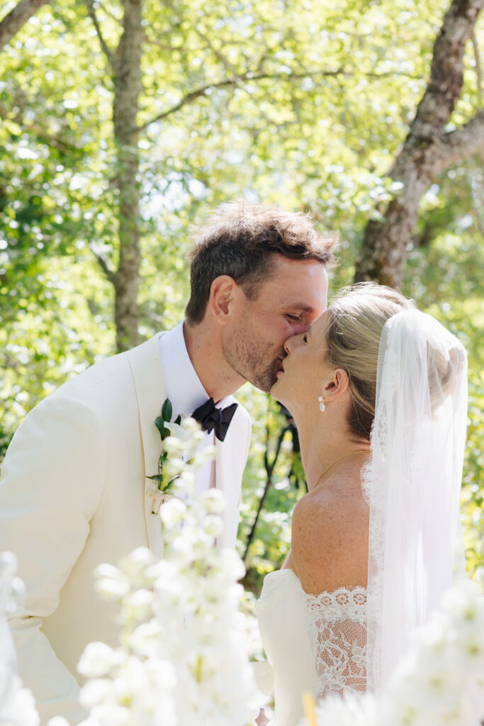 Bride and groom sharing a kiss in the greenery — Grange de Javon wedding
