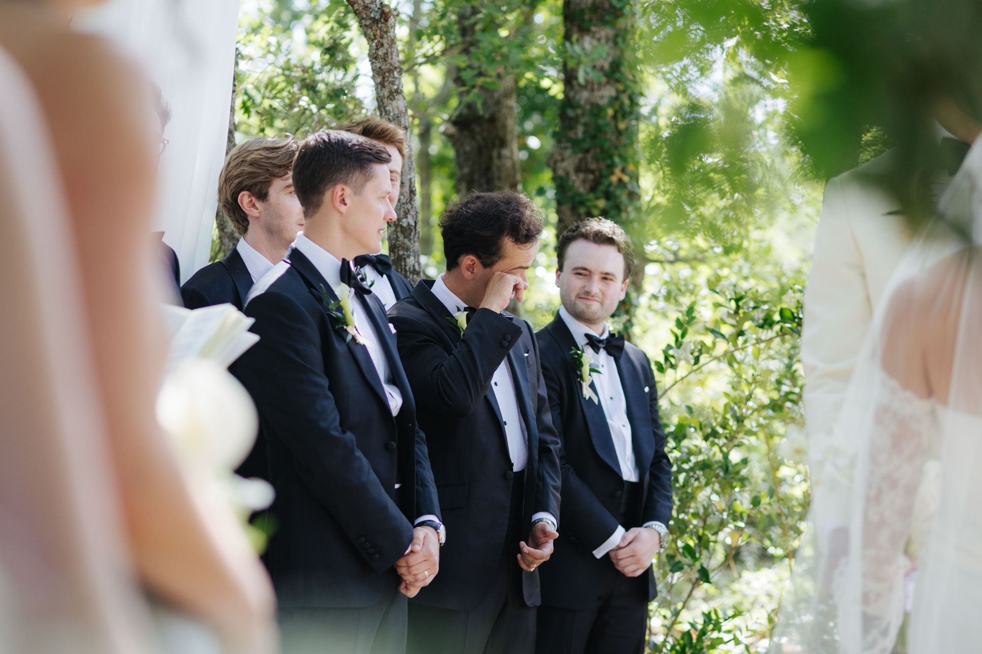 Wedding party watching the ceremony under the trees — Grange de Javon wedding