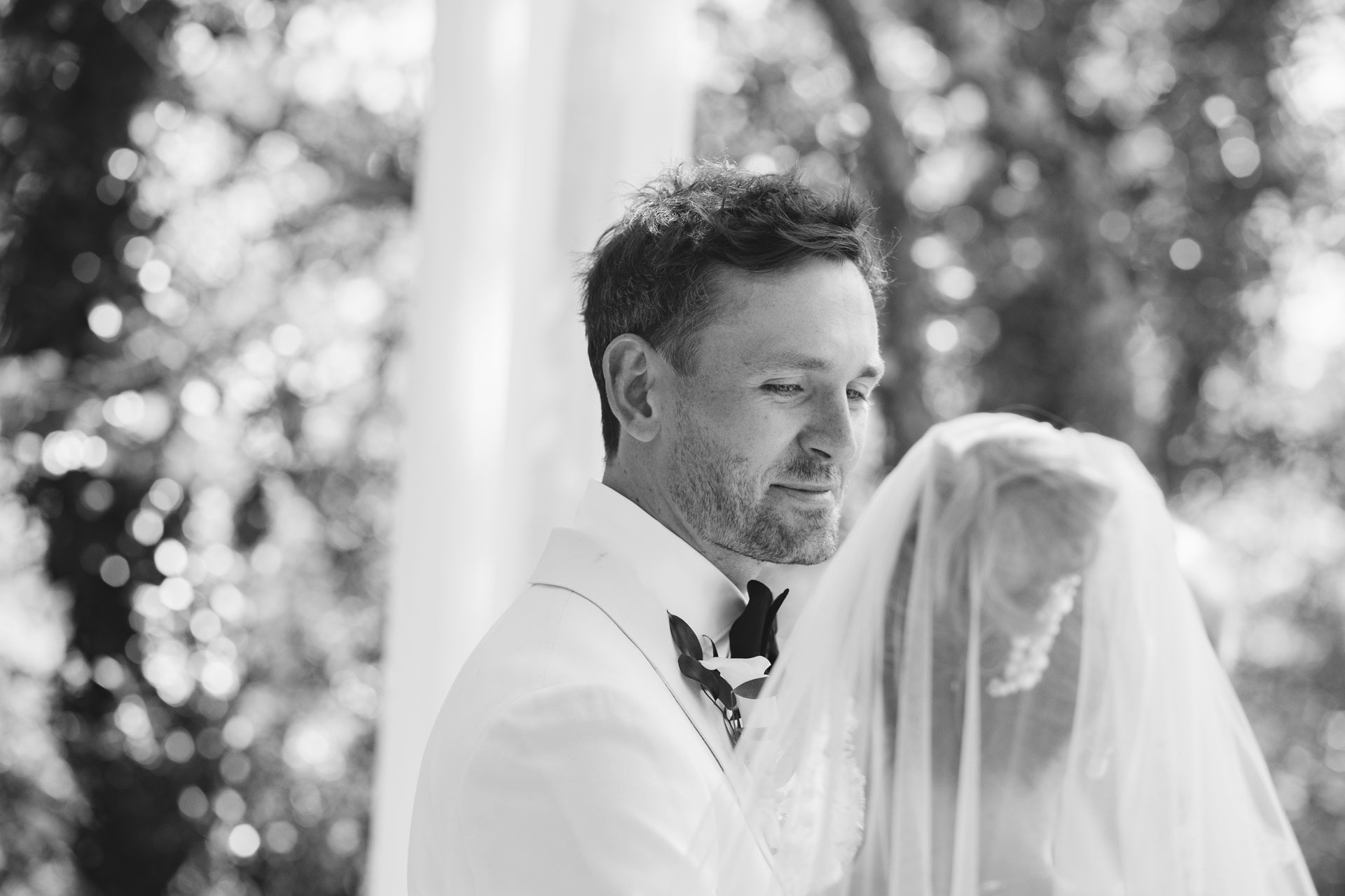 Groom framed by the bride's veil, black and white — Grange de Javon, Provence