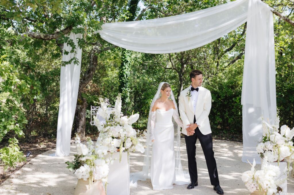 Bride and groom beneath the floral ceremony arch — Grange de Javon wedding
