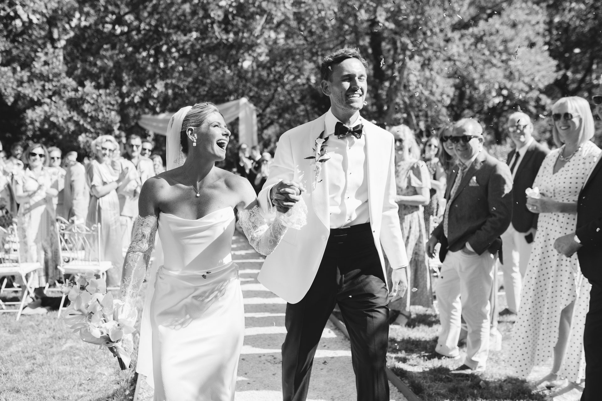 Newlyweds walking back up the aisle through guests — Grange de Javon, Provence