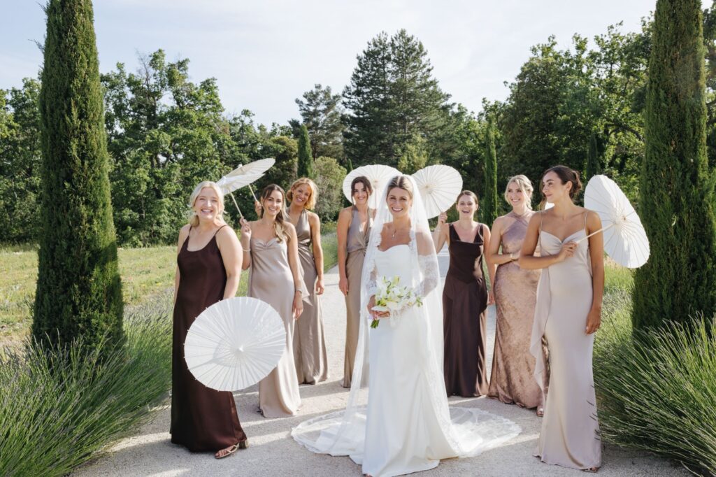Wedding party with white parasols among the cypress trees — Grange de Javon wedding