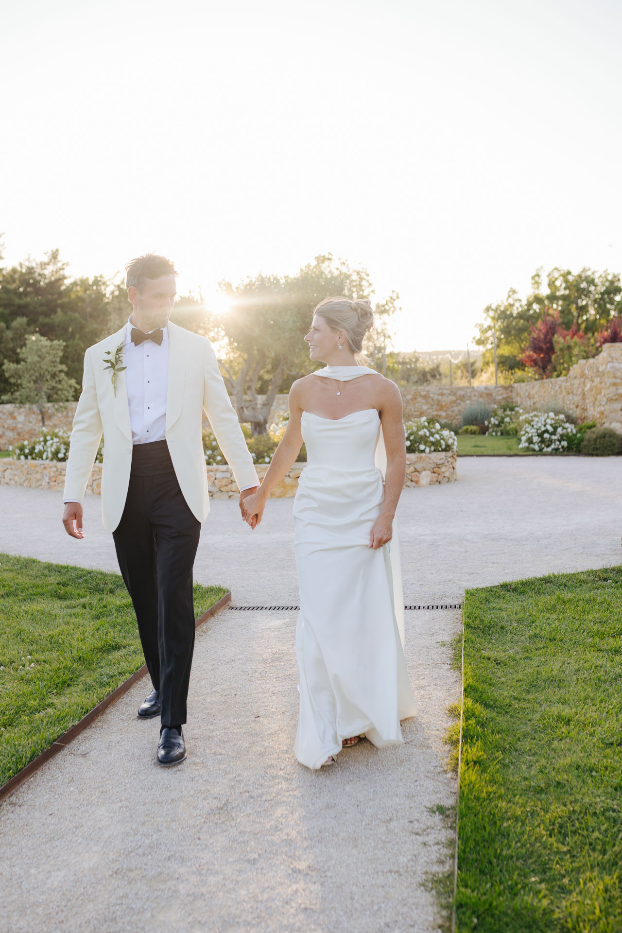 Bride and groom walking hand in hand at golden hour — Grange de Javon wedding