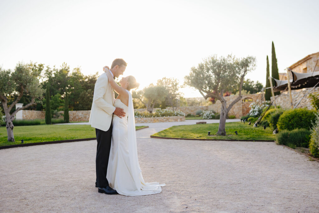 Bride and groom kissing in the garden at sunset — Grange de Javon wedding