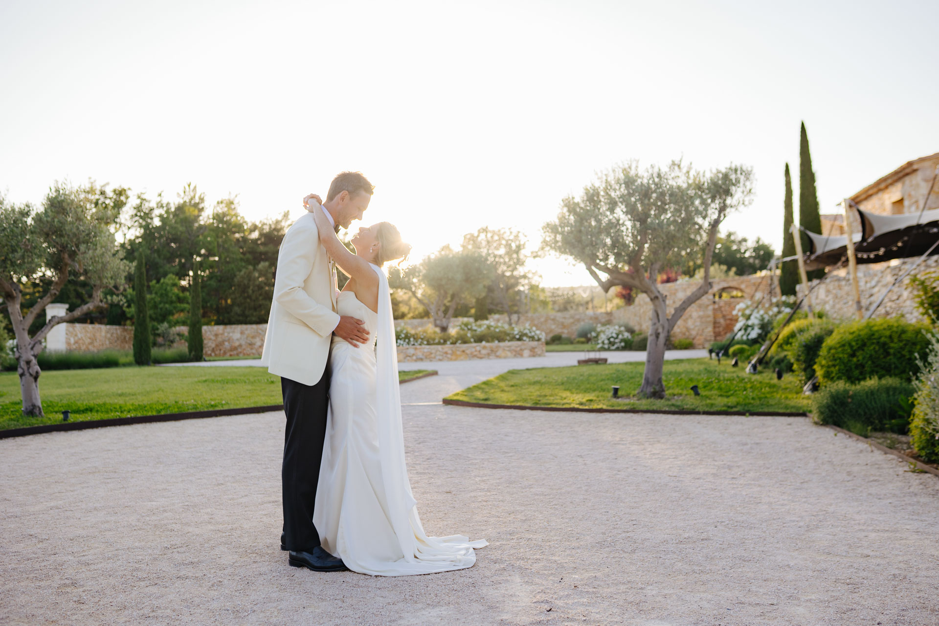 Bride and groom kissing in the garden at sunset — Grange de Javon wedding