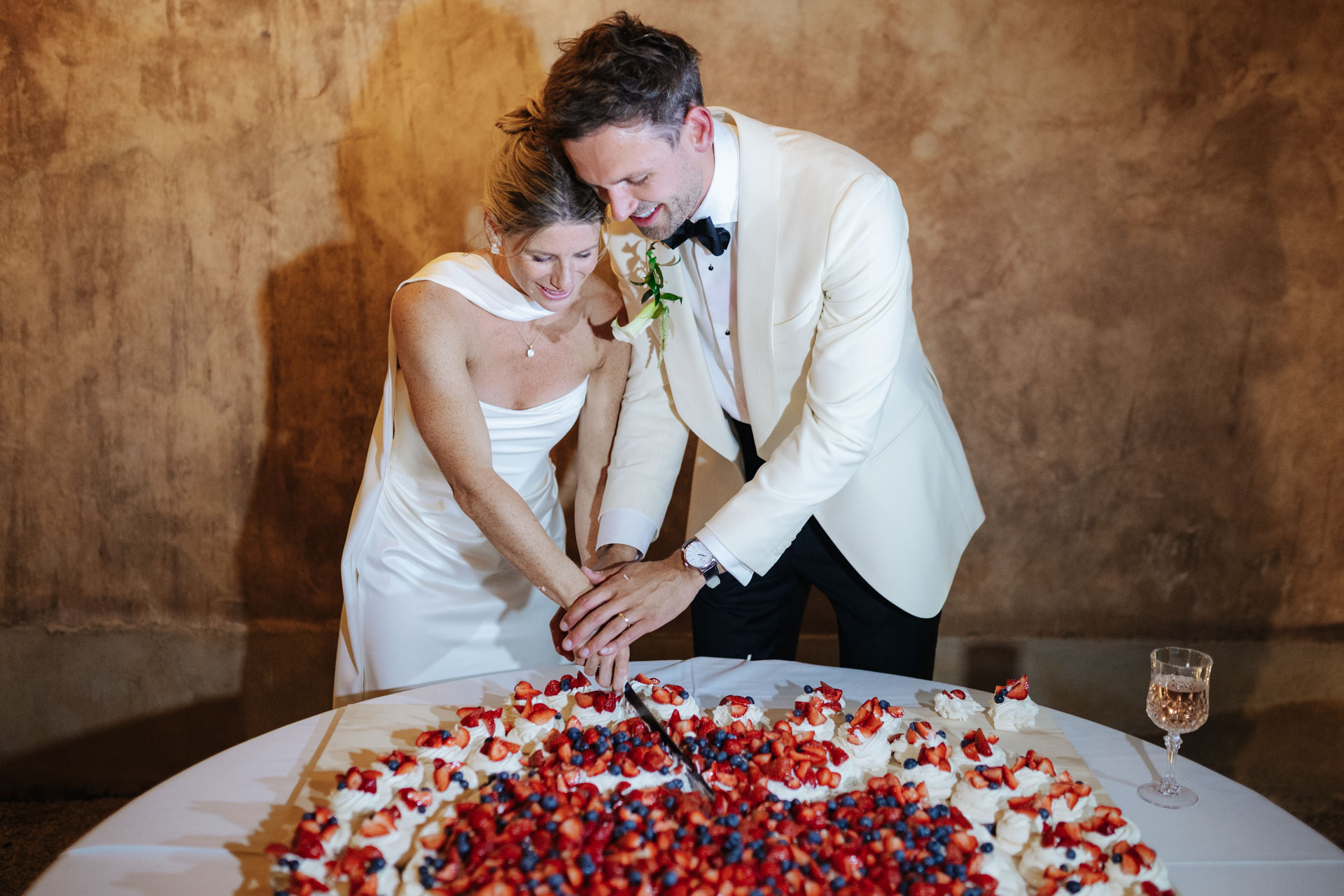 Bride and groom cutting the berry-topped wedding cake — Grange de Javon, Provence