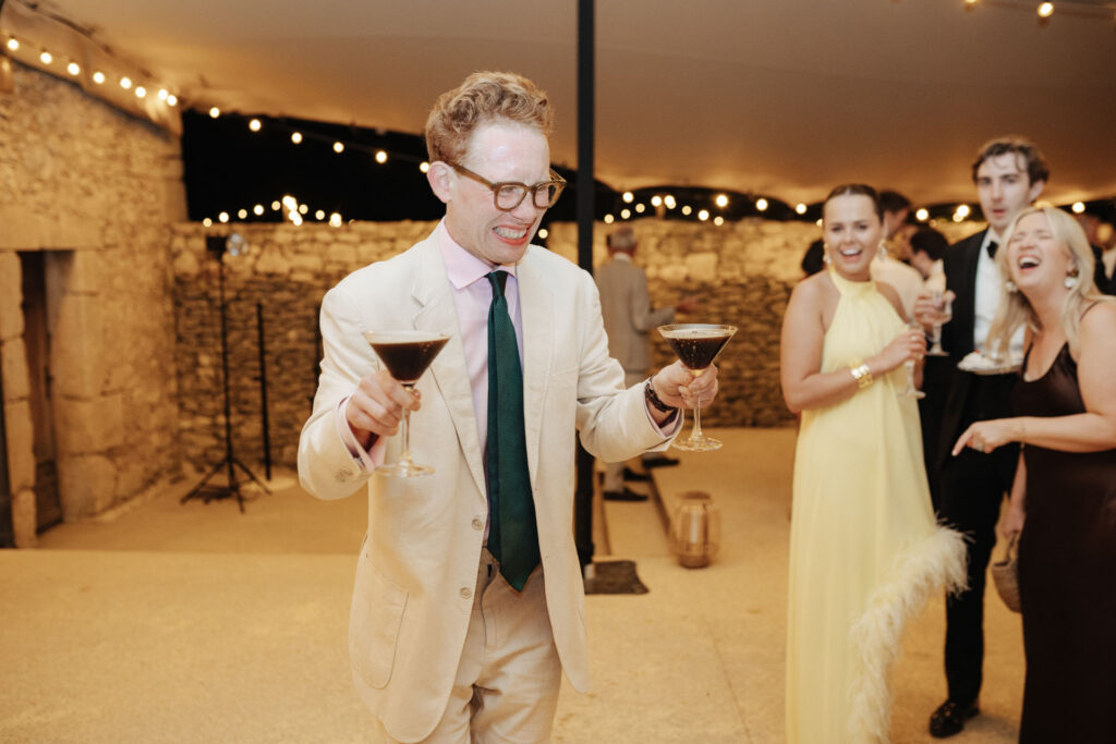 Guests mingling with drinks in the reception barn — Grange de Javon wedding