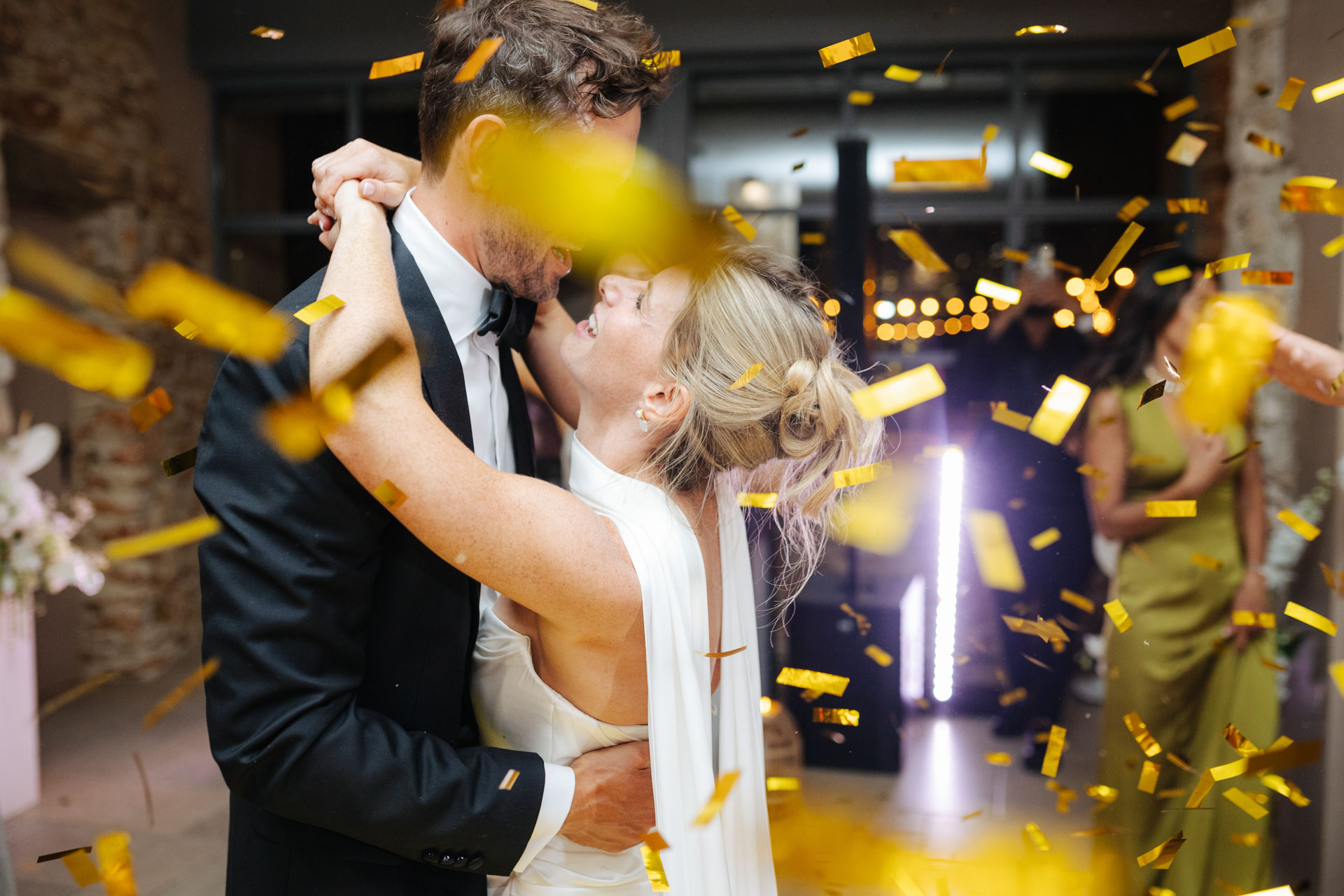 Bride and groom kissing amid golden confetti — Grange de Javon wedding