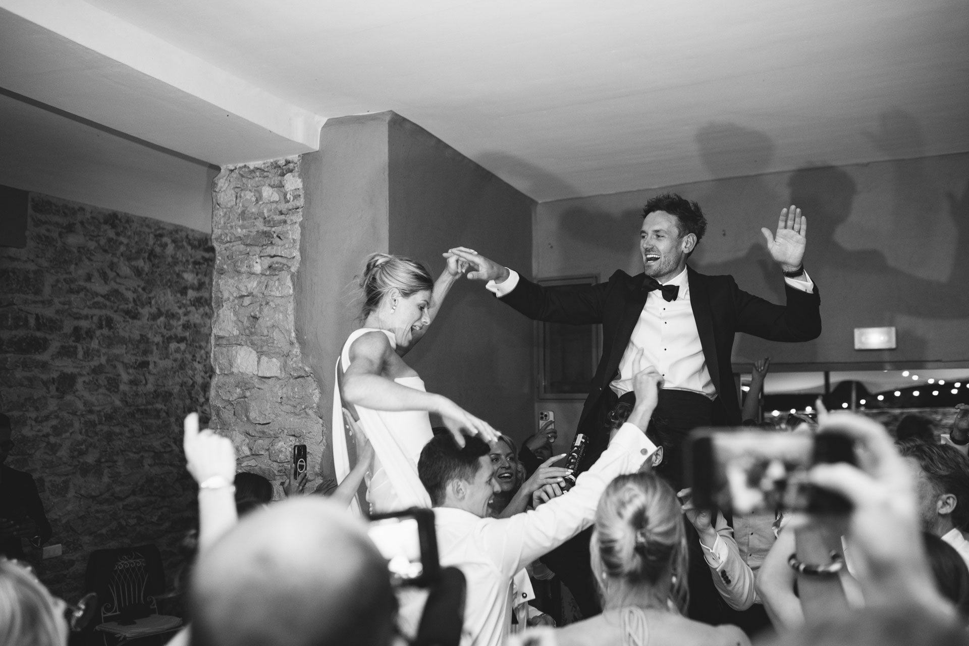 Newlyweds celebrating with raised hands at the party — Grange de Javon wedding