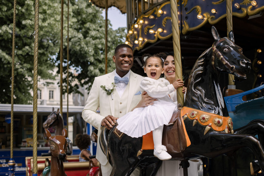 Marié riant avec sa fille sur un cheval de carrousel
