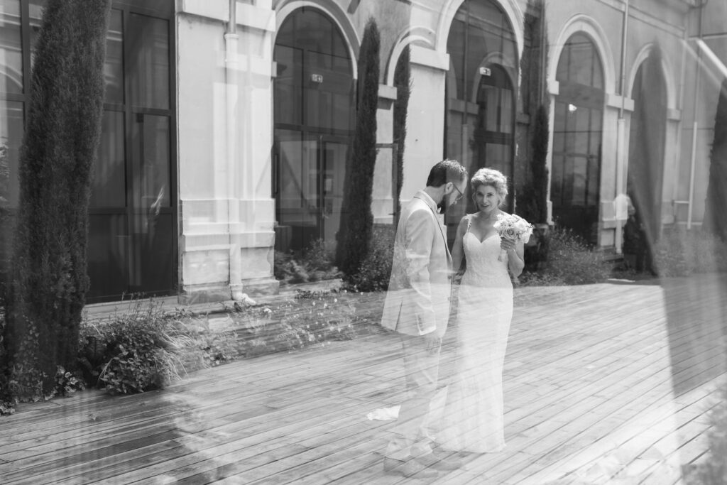 Portrait artistique en double exposition d'un couple de mariés dans une cour