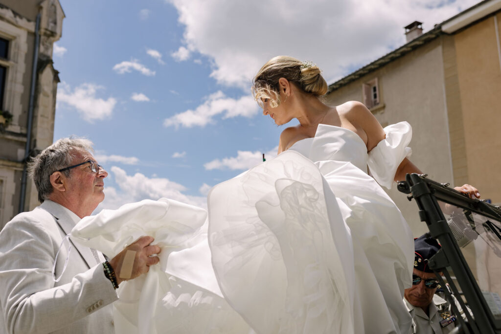 Mariée portée par son père avant la cérémonie, robe à volumineux drapé