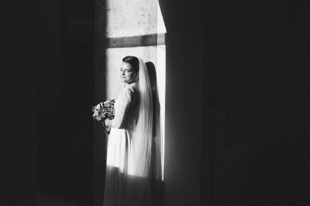 Portrait de mariée à contre-jour près d'une fenêtre
