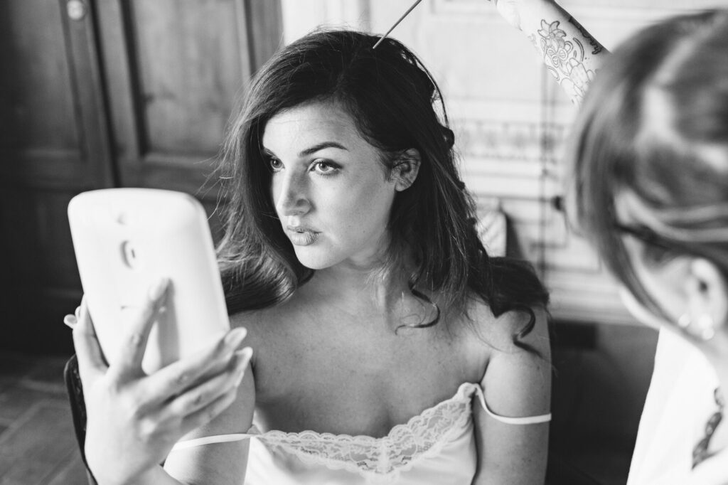 Bride checking her reflection during preparations, black and white, Villa Buonvisi