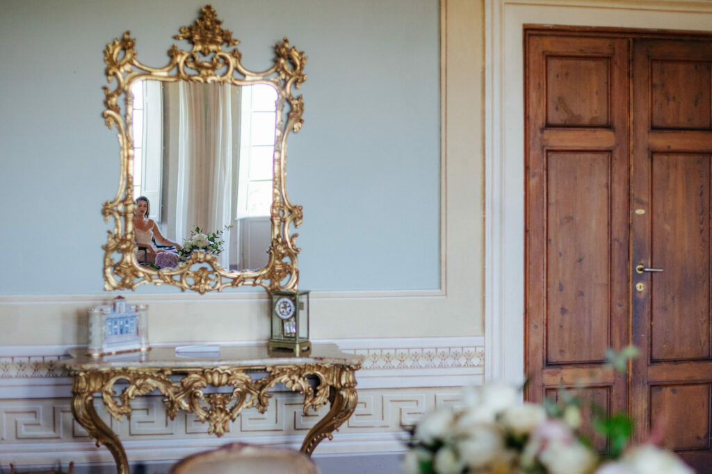 Bride reflected in a gilded antique mirror at Villa Buonvisi