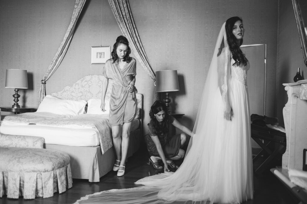 Bridesmaids adjusting the bride's train, black and white