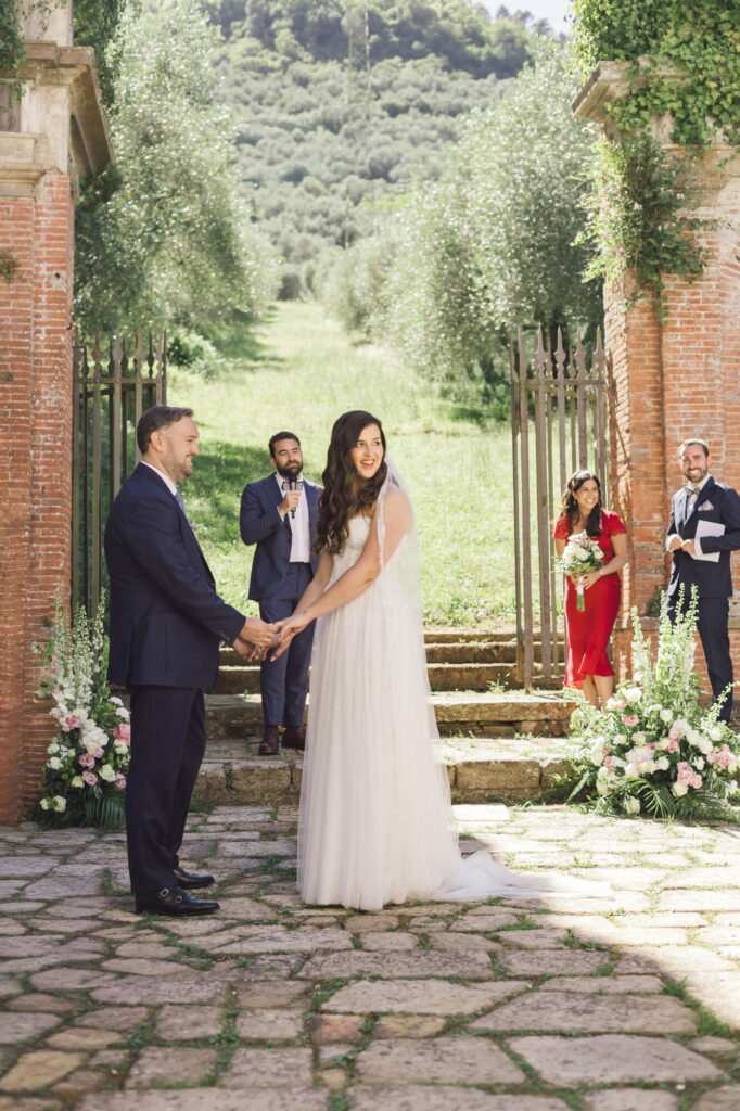 Hands joined at the altar with the olive grove behind them