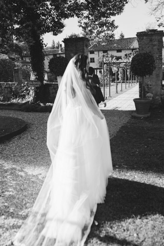 Newlyweds under an old brick archway at Villa Buonvisi
