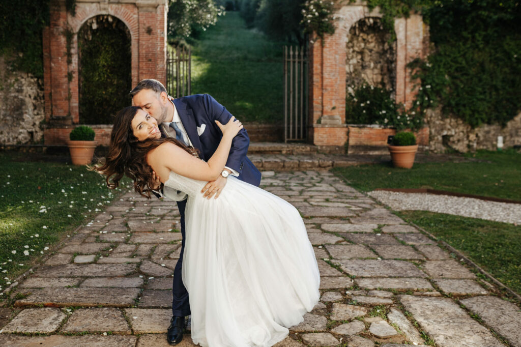 Groom spinning the bride before the brick ruins