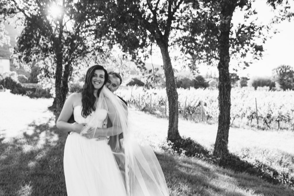 Couple walking between rows of vines at the villa's vineyard, black and white