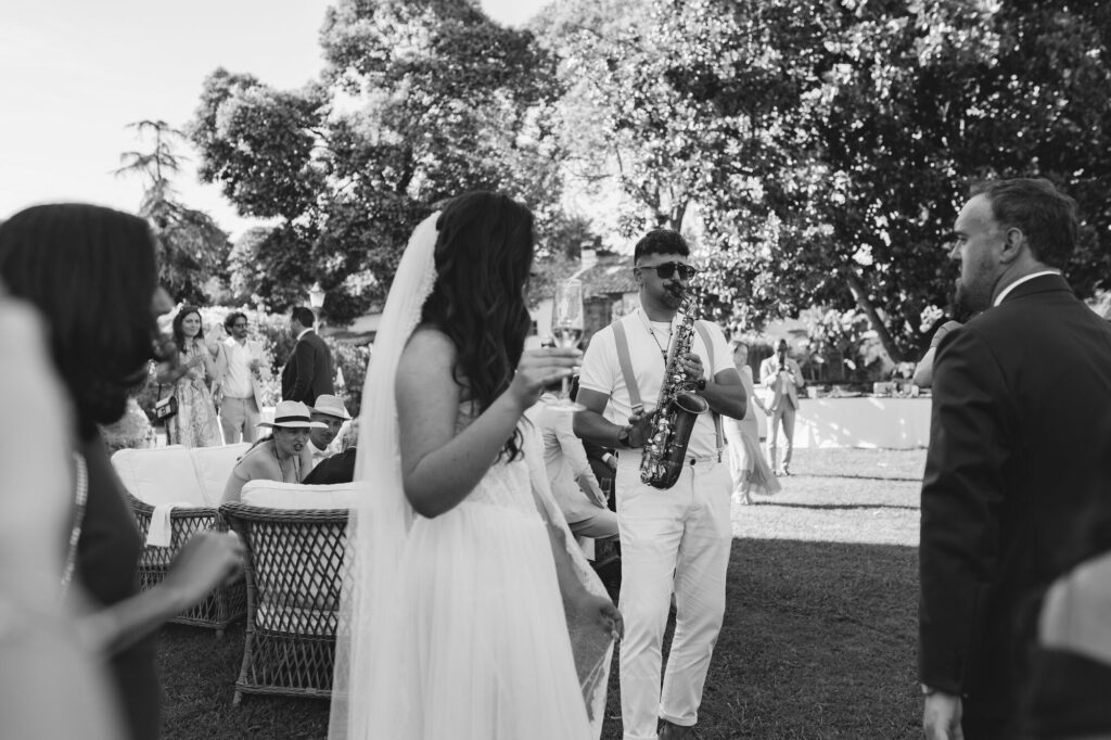 A saxophonist plays among guests during the aperitivo